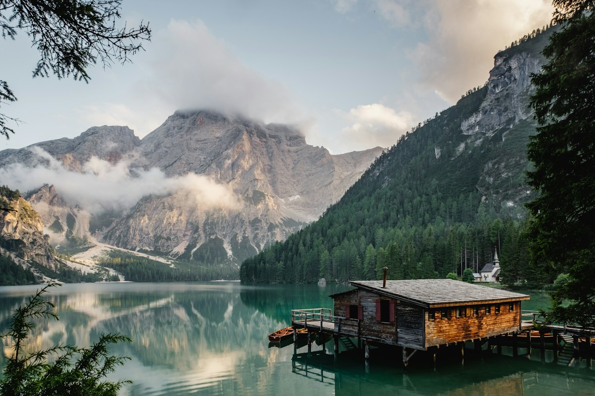 An alpine cabin reflected in a quiet lake